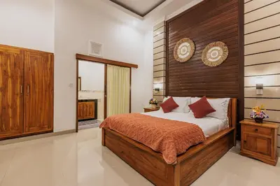 a bedroom with a large bed with a wooden headboard at Padma Villa I in Legian