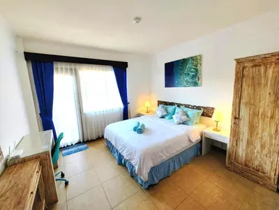a bedroom with a bed with blue pillows at Private Apartment inside Beach Resort Jayakarta in Seminyak