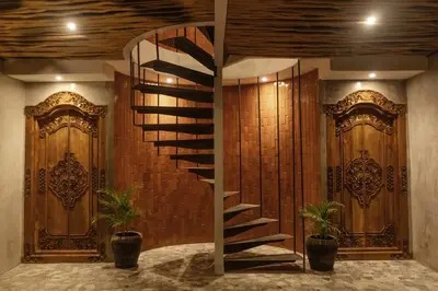 a spiral staircase in a room with wooden doors at Goestlie Berawa in Canggu