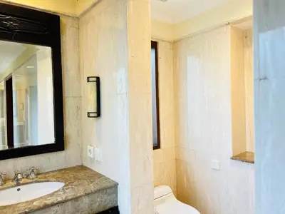 a bathroom with a sink and a toilet and a mirror at Mai Villa in Jimbaran