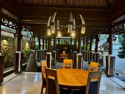 a dining room with a wooden table and chairs at Mai Villa in Jimbaran