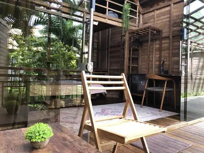 a wooden chair sitting on top of a wooden table at Bali WOW! Bungalows, Nusa Dua Benoa in Nusa Dua