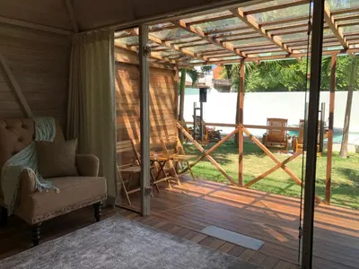 a screened in porch with a chair and a table at Bali WOW! Bungalows, Nusa Dua Benoa in Nusa Dua