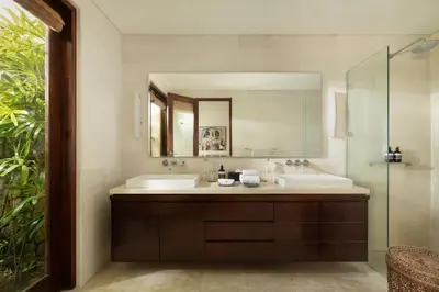 a bathroom with two sinks and a mirror at The Suar Seminyak by Nakula in Seminyak