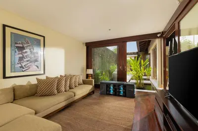 a living room with a couch and a flat screen tv at The Suar Seminyak by Nakula in Seminyak