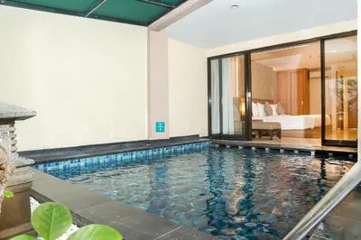 a pool in a hotel room with a bedroom at Cross Vibe Paasha Atelier Bali Kuta in Kuta