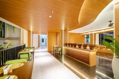 a restaurant with wooden ceilings and tables and chairs at Cross Vibe Paasha Atelier Bali Kuta in Kuta