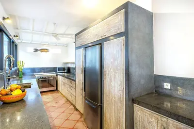 a kitchen with a stainless steel refrigerator and a bowl of fruit at La Villa Oberoi (6 BR) in Seminyak