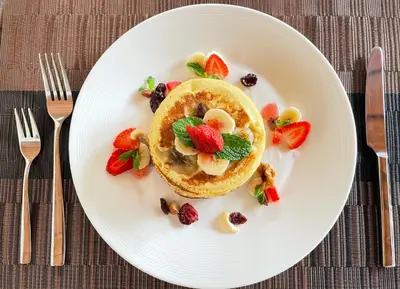 a plate with a stack of pancakes with fruit and nuts at Villa Dayak in Seminyak