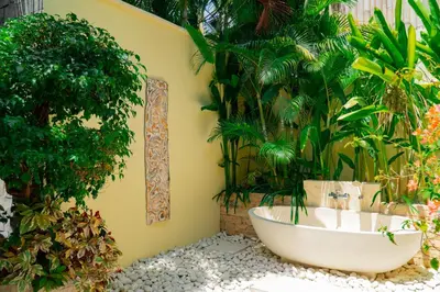 a bath tub in a garden with plants at Villa Dayak in Seminyak