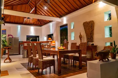 a dining room with a wooden table and chairs at Villa Dayak in Seminyak