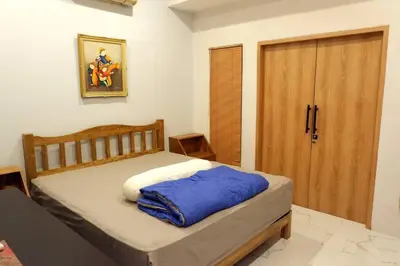 a bedroom with a bed and a wooden door at Villa Bale Damai Denpasar in Seminyak