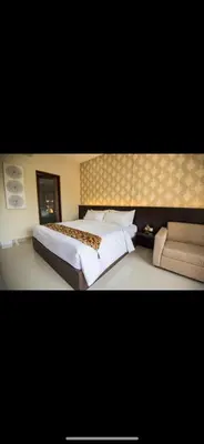 a bedroom with a large bed and a couch at Legian Bisma Suite in Seminyak
