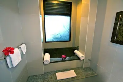 a bathroom with a mirror and a window and towels at 5 Bedroom Holiday Villa - Kuta Regency B8 in Kuta