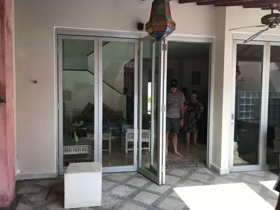 a man standing in a glass door of a house at 5 Bedroom Holiday Villa - Kuta Regency B8 in Kuta