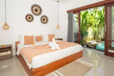 a bedroom with a bed with a stuffed animal on it at Villa bella wilson in Seminyak