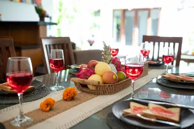 a table with a basket of fruit and wine glasses at Villa bella wilson in Seminyak