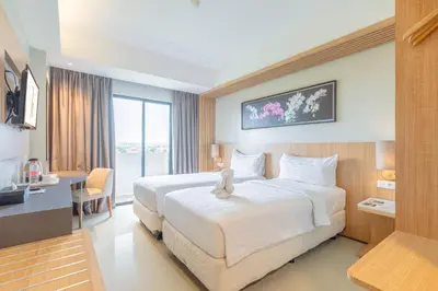 a hotel room with a bed with a teddy bear on it at Horison Le Aman Bali in Jimbaran