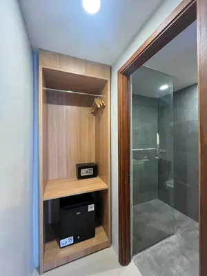 a bathroom with a walk in shower and a glass door at Horison Le Aman Bali in Jimbaran
