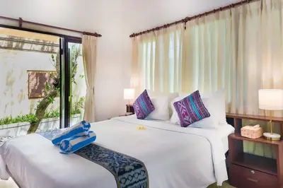 a hotel room with two beds and a window at Villa Tunjung Batubelig Canggu in Canggu
