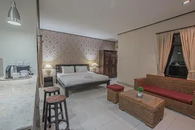 a bedroom with a bed and some chairs and a couch at Panorama Cottages I in Legian