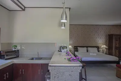 a kitchen with a sink and a bed in a room at Panorama Cottages I in Legian