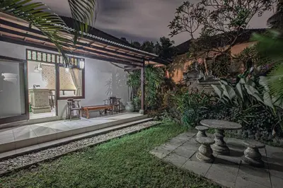 a garden with a table and a tv in a house at Panorama Cottages I in Legian