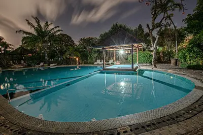 a large swimming pool at night with a gazebo at Panorama Cottages I in Legian