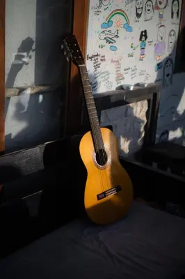 a guitar sitting on a couch in a room at Sunshot Hostel in Legian