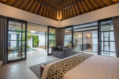 a bedroom with a large bed and a couch at The Kon's Villa Bali Seminyak in Seminyak
