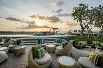 a patio with couches and chairs on a deck at AYANA Segara Bali in Jimbaran