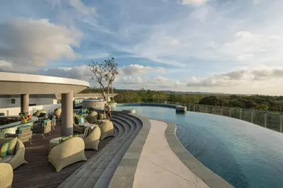 a resort with a swimming pool and chairs on a deck at AYANA Segara Bali in Jimbaran