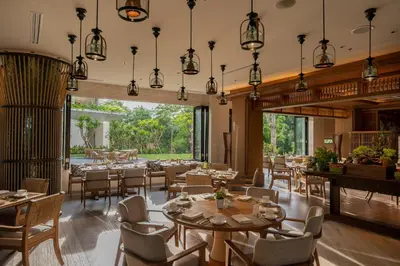 a restaurant with tables and chairs and large windows at AYANA Segara Bali in Jimbaran