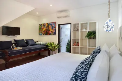 a bedroom with a bed and a couch at Villa Elleo in Seminyak