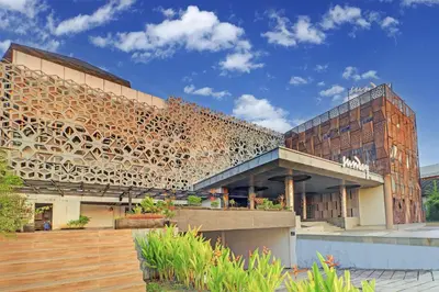 a building with a wooden facade at Sunday Hotel Arshika Sunset Road in Kuta