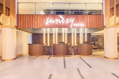 a lobby of a luxury hotel with a sign on the wall at Sunday Hotel Arshika Sunset Road in Kuta