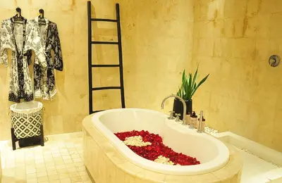 a bathroom with a bath tub filled with red flowers at Villa Zensa @ The Residence Seminyak in Seminyak