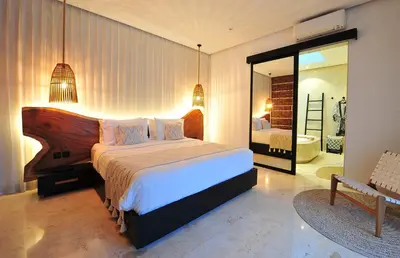 a bedroom with a large bed and a bathroom at Villa Zensa @ The Residence Seminyak in Seminyak