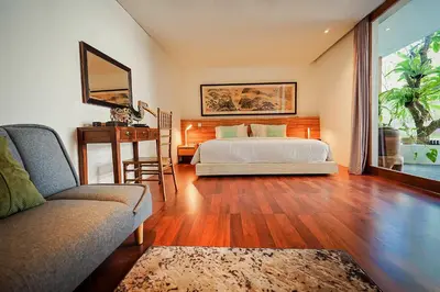 a bedroom with a bed and a table and a couch at Bias Villa Seminyak in Seminyak