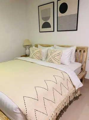 a bedroom with a large bed with a black and white blanket at Casa Praja in Seminyak