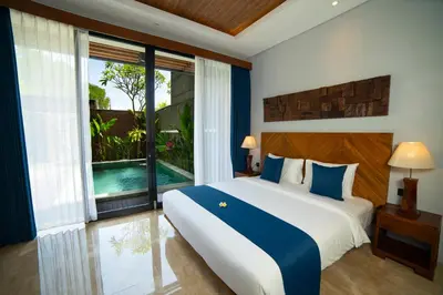 a bedroom with a large bed and a large window at Villa Bulan Bali in Jimbaran