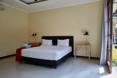 a bedroom with a large bed and two tables at Villa Nicola in Seminyak