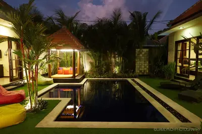 a backyard with a swimming pool and a house at Villa Jae in Seminyak