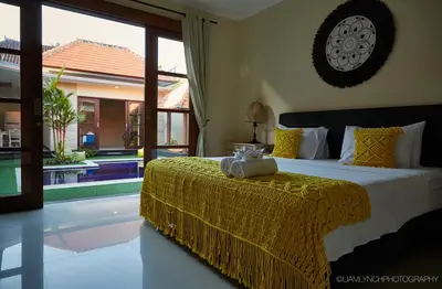 a bedroom with a bed with a yellow bedspread at Villa Jae in Seminyak