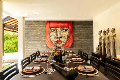 a dining room with a table with a mask on the wall at PROMO Tropical 3 BD Villa with office and parking in Kerobokan