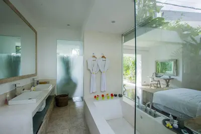 a bathroom with a shower and a sink and a bed at Villa Jumah in Canggu