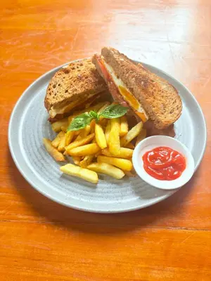a plate with a sandwich and french fries and ketchup at Rahayu Guest House Seminyak in Seminyak