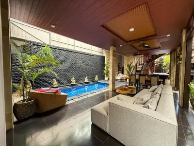 a living room with a couch and a swimming pool at Rahayu Guest House Seminyak in Seminyak