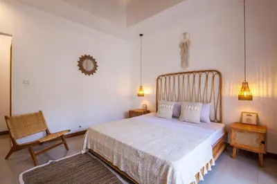 a bedroom with a large bed and a chair at Simple & Magical Villas . Villa Sambali 2 in Kuta