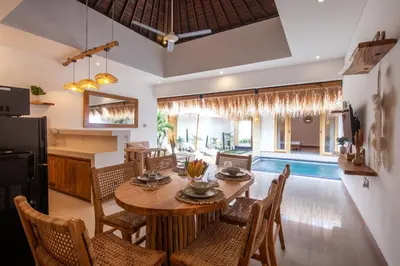 a dining room with a table and chairs and a pool at Simple & Magical Villas . Villa Sambali 2 in Kuta